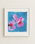 The image is a framed watercolor painting depicting a vibrant blue background with three pink flowers.