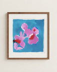 The image is a framed painting of two pink flowers against a blue background.