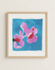 The image is a framed painting of two pink flowers against a blue background.