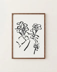 The image is a framed artwork depicting a stylized floral design in black and white.